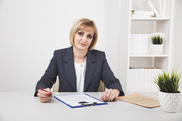 Attractive blond woman working with paper at her workplace