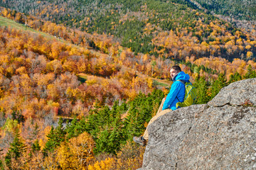 Backpacker man hiking at Artist's Bluff in autumn. Fall colours in Franconia Notch State Park....
