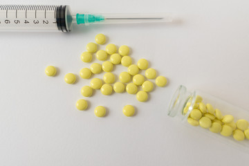 Medical syringe and pills on white background, health and vaccination concept.
