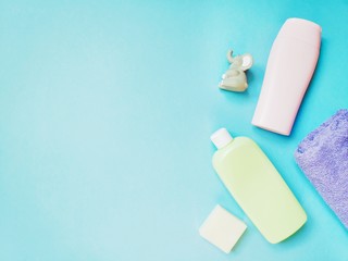 Flat lay composition photography. View from above shampoo. shower gel , soap and rubber toy elephant. Natural baby care products on a blue background