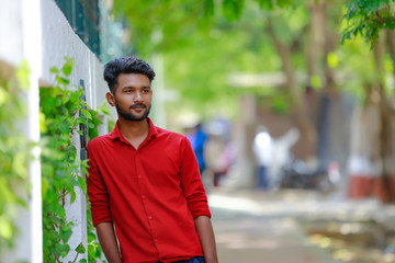 Indian / Asian Collage boy in red shirt and Showing expression 