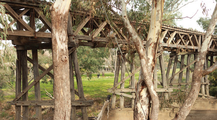 old timber hardwood discontinued railway bridge river crossing in a rural farming town, Victoria, Australia