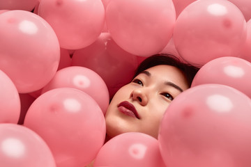 Fototapeta na wymiar Dreamy Asian lady under balloons