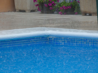 Fototapeta na wymiar Lluvia cayando en el agua de una piscina; tormenta sobre una piscina