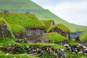 View of fishing village in Koltur island. Faroe Islands. Green roof houses. Nordic natural landscape.