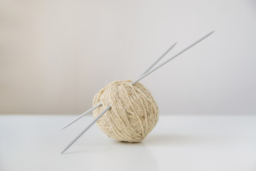 ball of yarn for knitting wool, natural, beige on white background and spokes gray