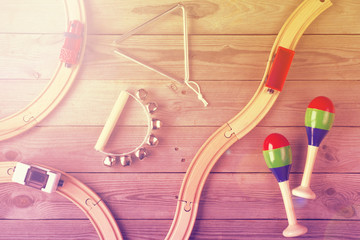 Toy train and wooden rails on wooden background. Top view. Copy space