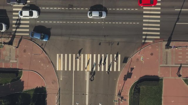 Aerial view of people walking along a pedestrian crossing at the crossroad