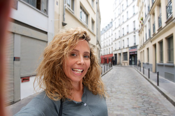 attractive middle age woman taking selfie in the city © mimagephotos