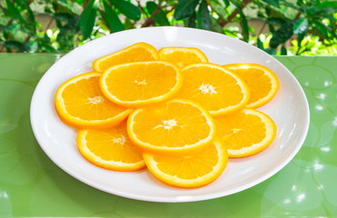 Close up shot of orange slices on white plate. Healthy and vegetarian eating