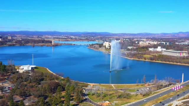 Dolly aerial view of Lake Burley Griffin with the Captain James Cook Memorial Jet, the National Library of Australia and Commonwealth Bridge in Canberra, the capital of Australia