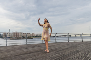 Fototapeta premium waterfront girl in a white dress dancing