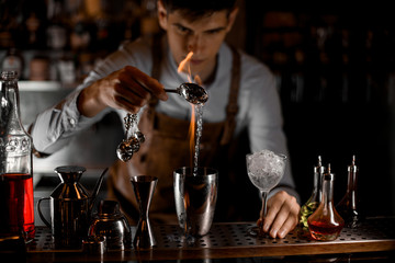 Bartender pouring alcohol from spoon to shaker