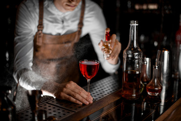 Bartender pours an alcohol drink with sprayer