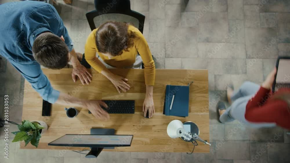 Poster Top View Camera Shot: Female Office Worker Uses Desktop Computer, Project Manager Stands Beside and gives Advice on Optimizing Workflow for Customer Experience Management. Gradually Unfocusing Picture