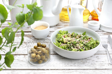 Fresh salad with olives, sun-dried tomatoes, sunflower seeds served with a sauce based on oil and herbs.