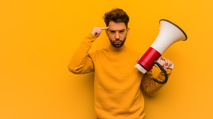 Young man holding a megaphone doing a concentration gesture