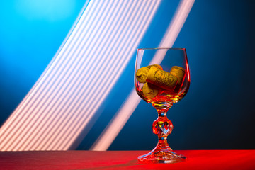 Wine glass with cork stoppers on abstract background