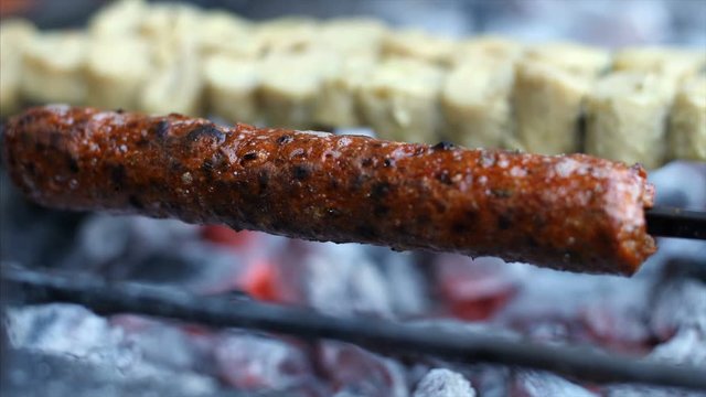 Mutton seekh kebab being flipped and cooked over the burning furnace . 