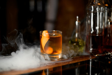 Glass of whiskey with ice in steam