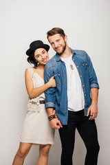 young couple in stylish clothes hugging, smiling and looking at camera