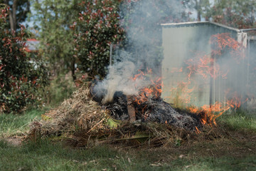 Man tending to fire controlled burn off of garden waste