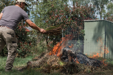 Man tending to fire controlled burn off of garden waste
