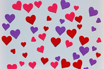 Red, pink and purple felt hearts on blue background