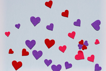Red, pink and purple felt hearts on blue background