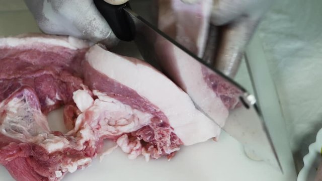 Close up cadre of a chef removing the skin layer of a raw pork meat - Keto diet
