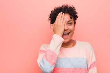 Young mixed african american teenager woman having fun covering half of face with palm.