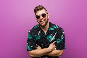Young man wearing a vacation look laughing and having fun.