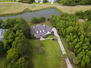 High angle aerial view of expensive home on wooded lot with pond. © Wollwerth Imagery