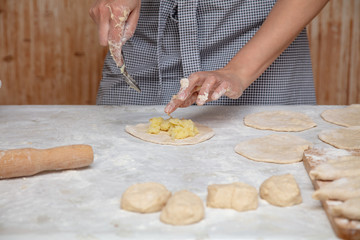 The hostess prepares the pies in the kitchen