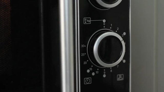Setting microwave timer to three minutes and turning microwave off - close angled shot