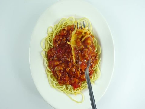 Spaghetti at fork on a white plate. Thin pasta arranged in rows. Long spaghetti, Food background concept.