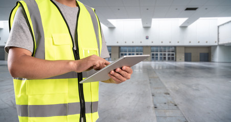 worker hand holding pad for check order pick time in empty warehouse