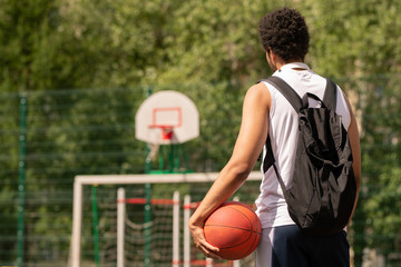 Young basketball player with ball ready for game standing on court