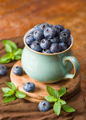 Fresh blueberry in a cup with leaves of mint