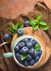 Fresh blueberry in a cup with leaves of mint