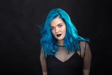 Fototapeta premium People, style and fashion concept - Close up portrait of young woman with blue long hair dressed in black dress