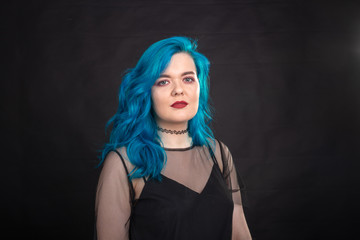 Sryle and fashion concept - Close up portrait of woman with blue long hair over black background