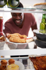 View Looking Out From Inside Of Refrigerator Filled With Takeaway Food As Man Opens Door