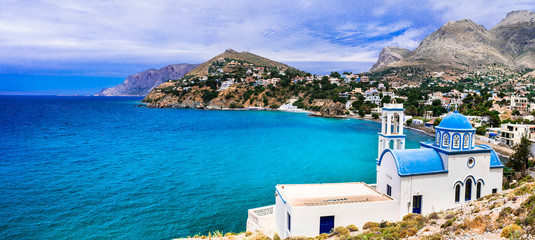 Scenery of Kalymnos island - picturesque church overloong the sea. Panormos