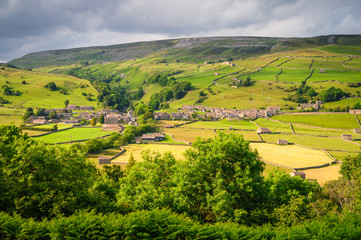 Fototapeta na wymiar Gunnerside Village meadows and barns, in Swaledale one of the most northerly dales in the Yorkshire Dales National Park, famous for its wildflower meadows and field barns