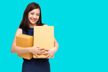 Young Asian entrepreneur holding parcel isolated on blue background, Teenager business owner online...