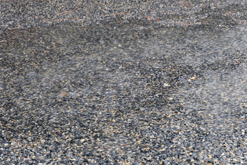 Rain drops rippling in a puddle