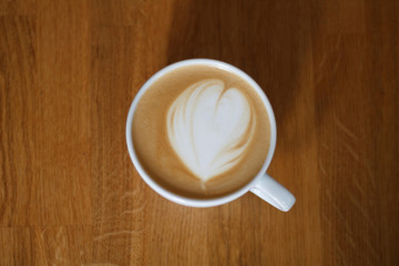 coffee in a Cup with a heart on a wooden table top view