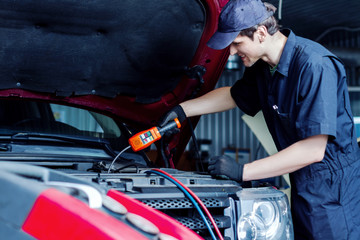 Repairman is conducting diagnostics and detecting problems of car conditioner by special freon leak...