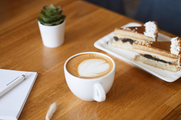cappuccino in a white cup on a wooden table.